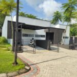 Rumah minimalis modern 1 lantai bernuansa hitam putih dengan carport, kanopi, pagar besi, dan halaman paving block.