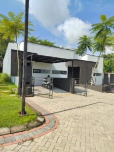 Rumah minimalis modern 1 lantai bernuansa hitam putih dengan carport, kanopi, pagar besi, dan halaman paving block.
