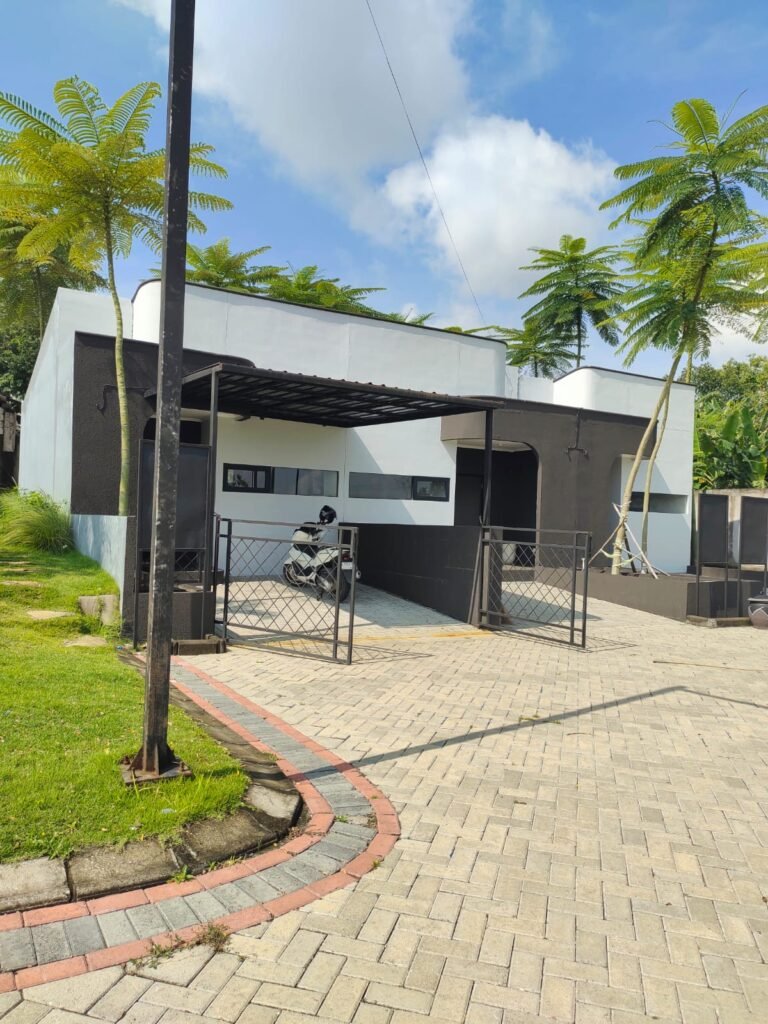 Rumah minimalis modern 1 lantai bernuansa hitam putih dengan carport, kanopi, pagar besi, dan halaman paving block.