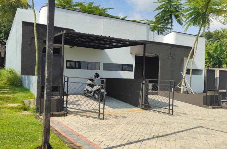 Rumah minimalis modern 1 lantai bernuansa hitam putih dengan carport, kanopi, pagar besi, dan halaman paving block.